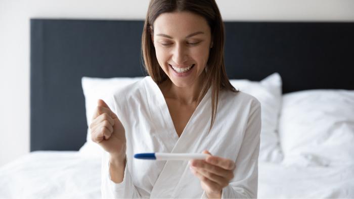 Mujer feliz con un test de embarazo en la mano