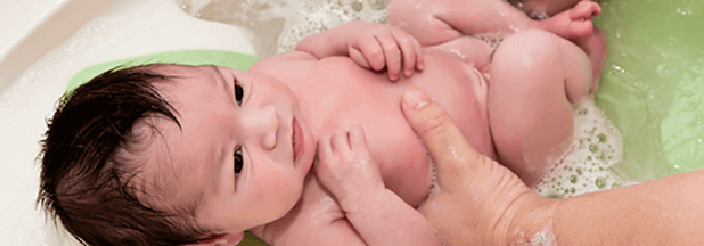 Adulto bañando a su recién nacido