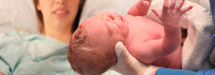 Bebé recién nacido en el momento del parto