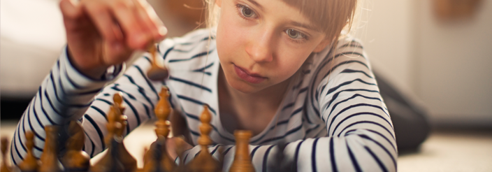 Niña jugando al ajedrez en casa