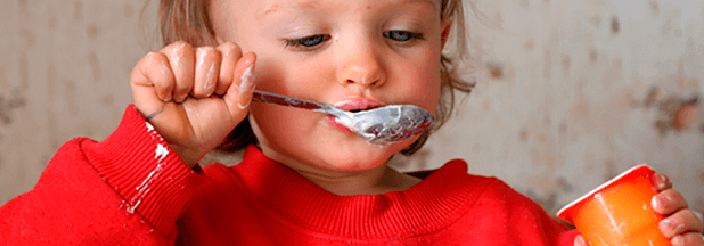 Niña comiendo un yogur