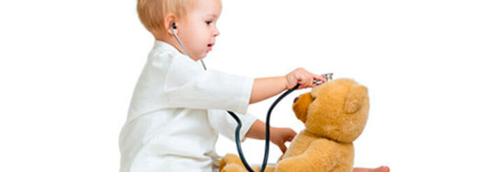 Niño jugando a ser médico con un oso de peluche