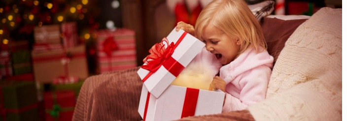 niña abriendo regalo de Navidad