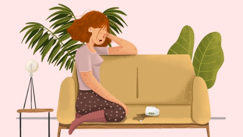 Mujer dormida sentada en el sofá con la taza de té vertida
