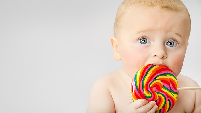 Bebé comiendo un dulce con azúcar