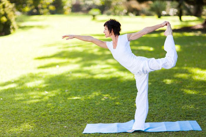 Mujer de mediana edad haciendo yoga al aire libre