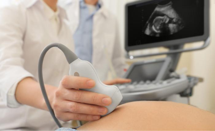  Ginecólogo realizando una ecografía a una mujer embarazada