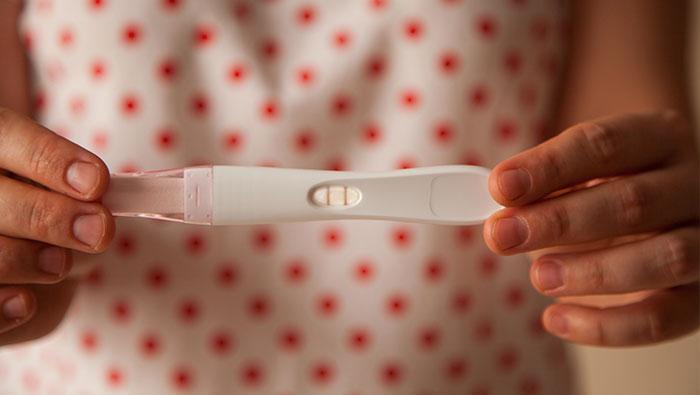 Manos de mujer sosteniendo un test de embarazo