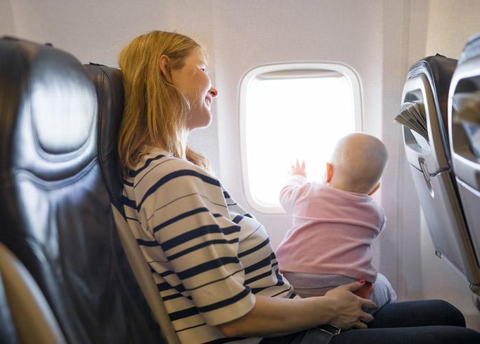Madre con su bebé viajando en avión