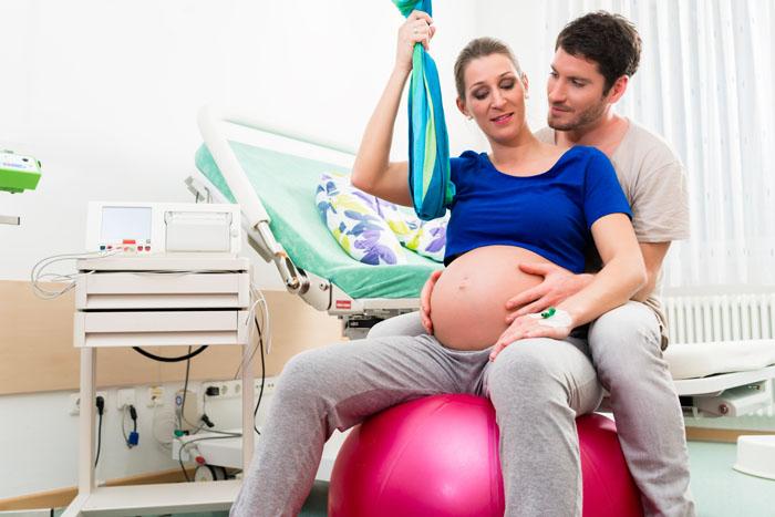 Mujer con pelota de Pilates para evitar el dolor en el parto