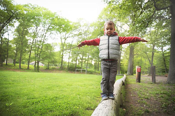 Niño haciendo equilibrios sobre un tronco