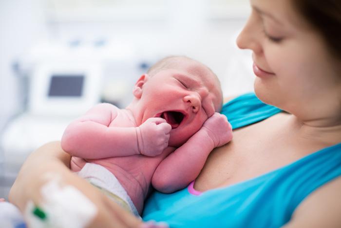 Madre sosteniendo a su bebé recién nacido en el hospital