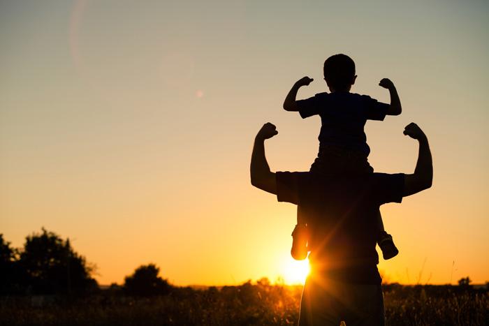 Padre e hijo jugando al aire libre al atardecer