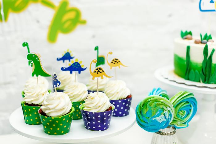 Dinosaurios de cartón decorando cupcakes de una fiesta de cumpleaños