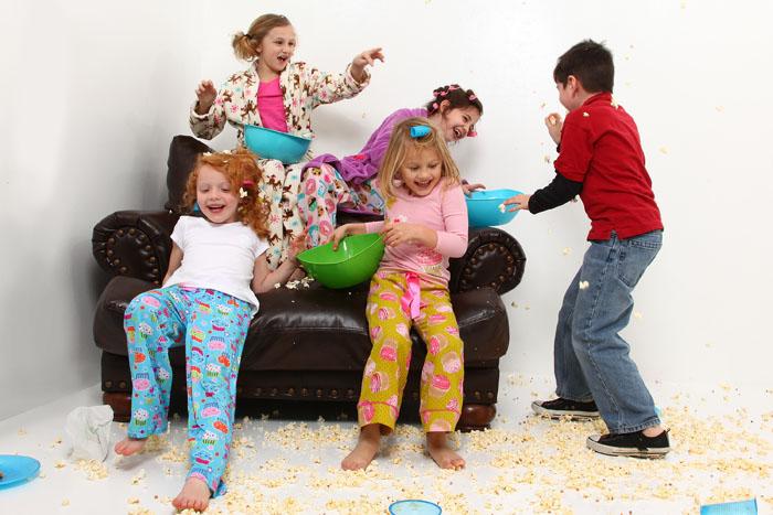 Niños en una fiesta de pijamas jugando con palomitas