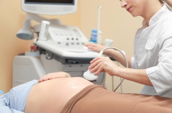 Doctora realizando una ecografía para escuchar el latido fetal