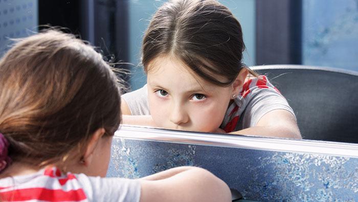 Niña sentada frente a un espejo