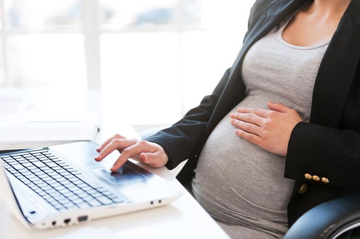 Embarazada trabajando y notando un movimiento del bebé