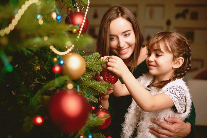 Madre e hija decorando el árbol de Navidad