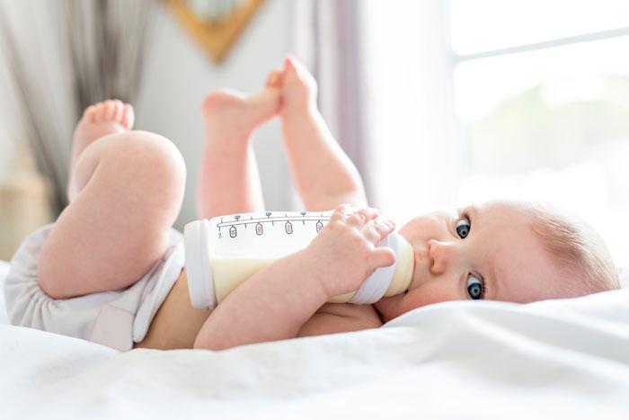 Bebé tomando leche de fórmula en un biberón