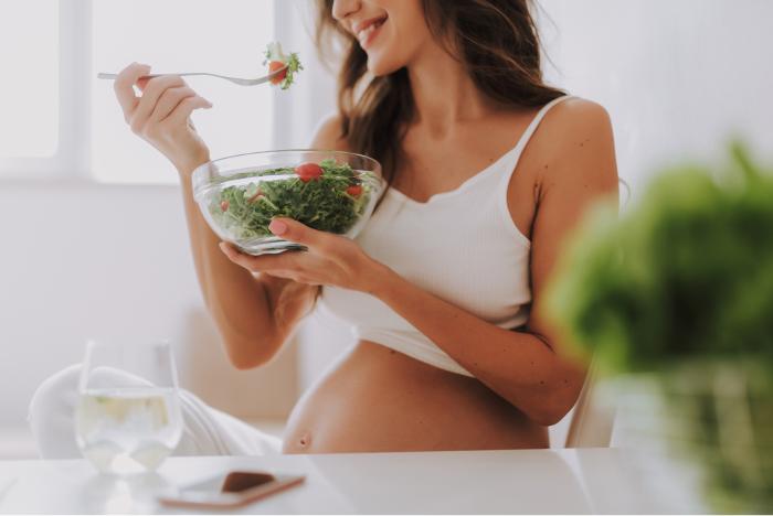 Mujer embarazada comiendo una ensalada