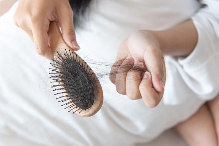 Mujer quitando pelo de su cepillo