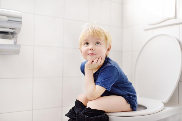 Niño orinando sentado en el váter