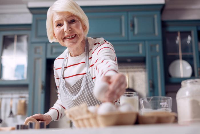Mujer de avanzada edad cogiendo un huevo