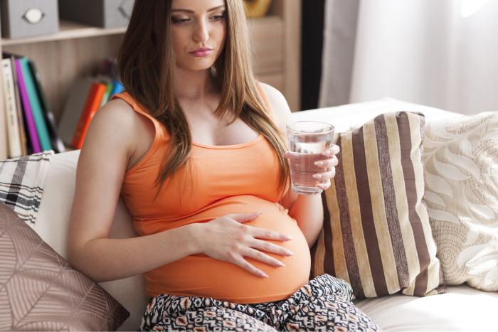 Mujer embarazada tomando un vaso de agua