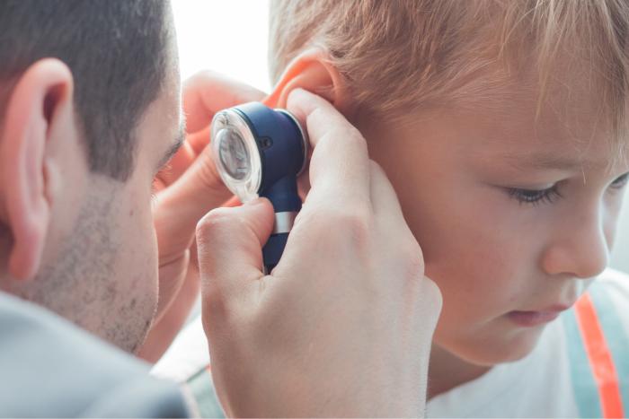 Médico revisando si un niño tiene un tapón de cera