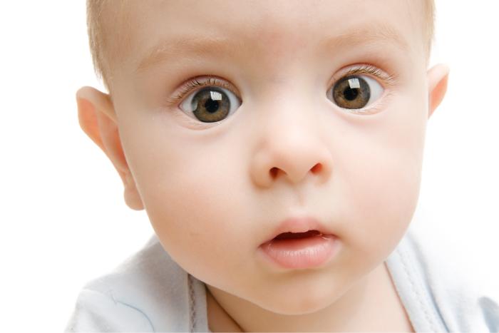  Bebé de grandes ojos marrones mirando a cámara