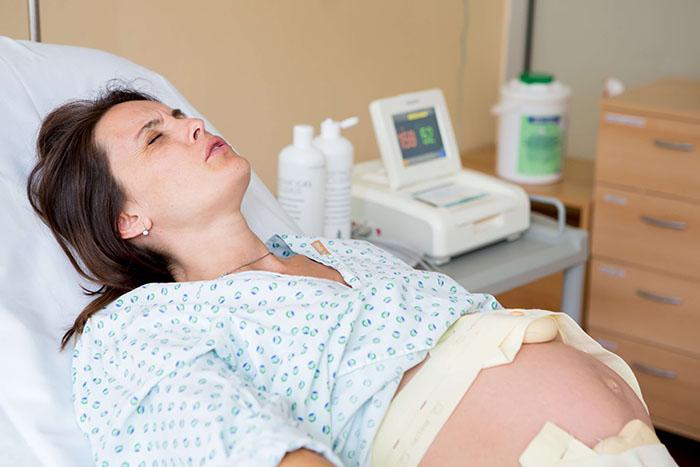 Mujer de parto en el hospital teniendo una contracción