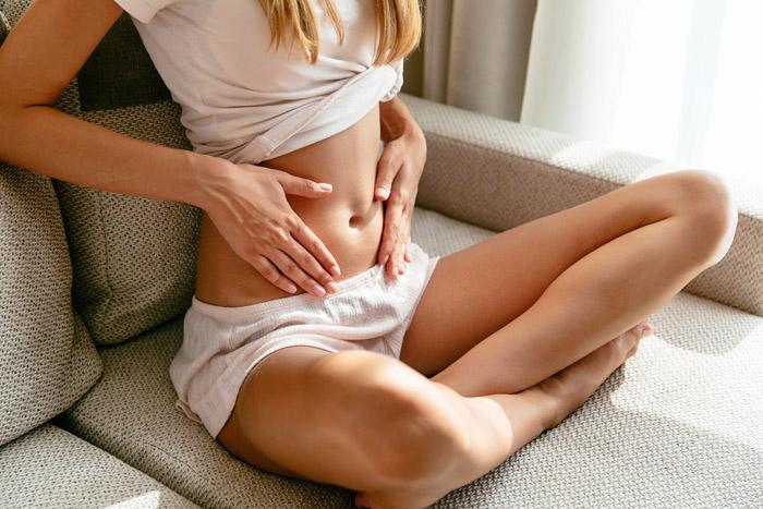 Mujer mostrando su tripa durante las primeras semanas semanas de su embarazo