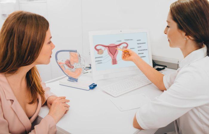 mujer en el ginecólogo mirando sus pruebas médicas de histerosalpinografíacon una doctora