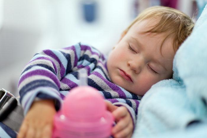 Bebé dormido tras tomar su biberón con leche de crecimiento