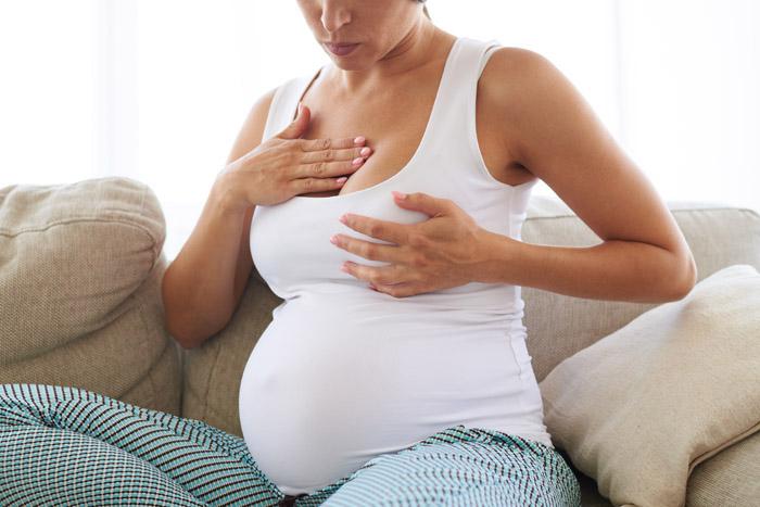 Mujer embarazada masajeándose el pecho