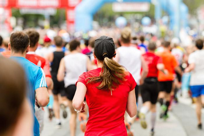 Mujer de espaldas corriendo un maratón