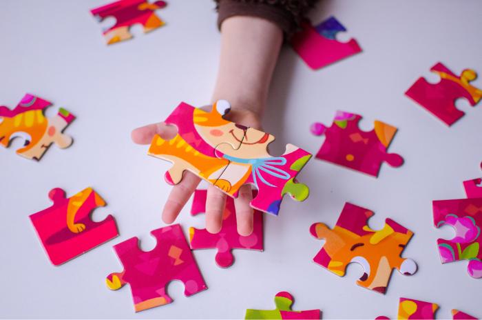  Mano de un niño sosteniendo algunas piezas de un puzzle