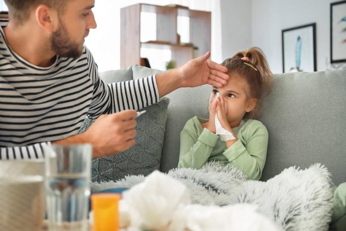 Padre cuidando a su hija enferma por gripe