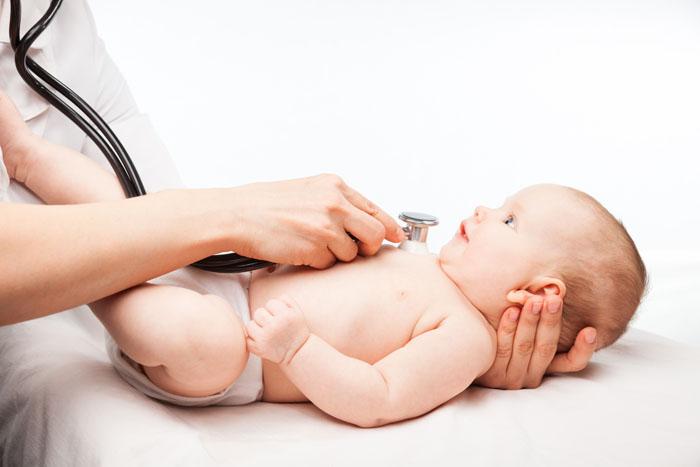 Bebé con tos atendido por el pediatra en la consulta