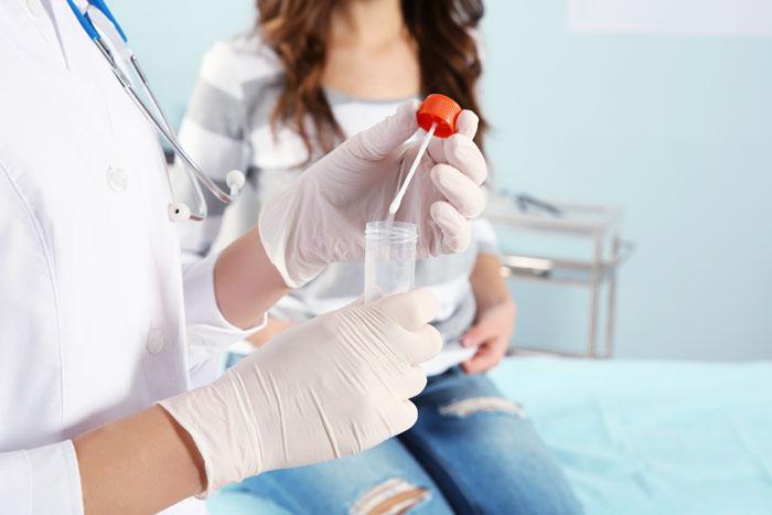 Ginecóloga realizando una prueba de candidiasis a una mujer embarazada