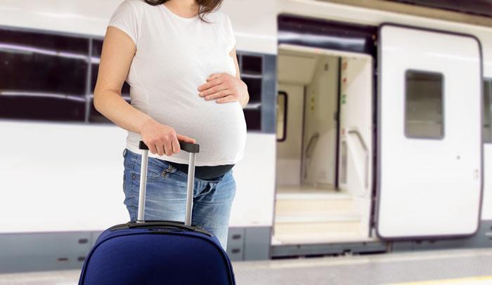 Mujer embarazada a punto de subir a un tren