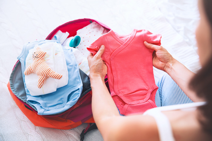 Mujer embarazada preparando la bolsa para el hospital