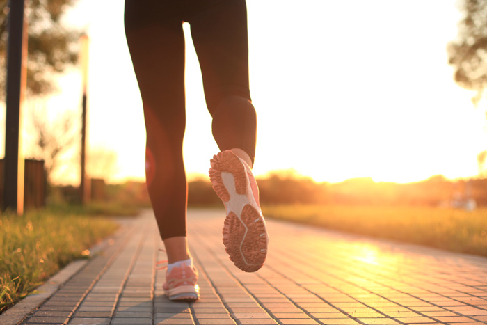 Piernas de mujer corriendo al atardecer