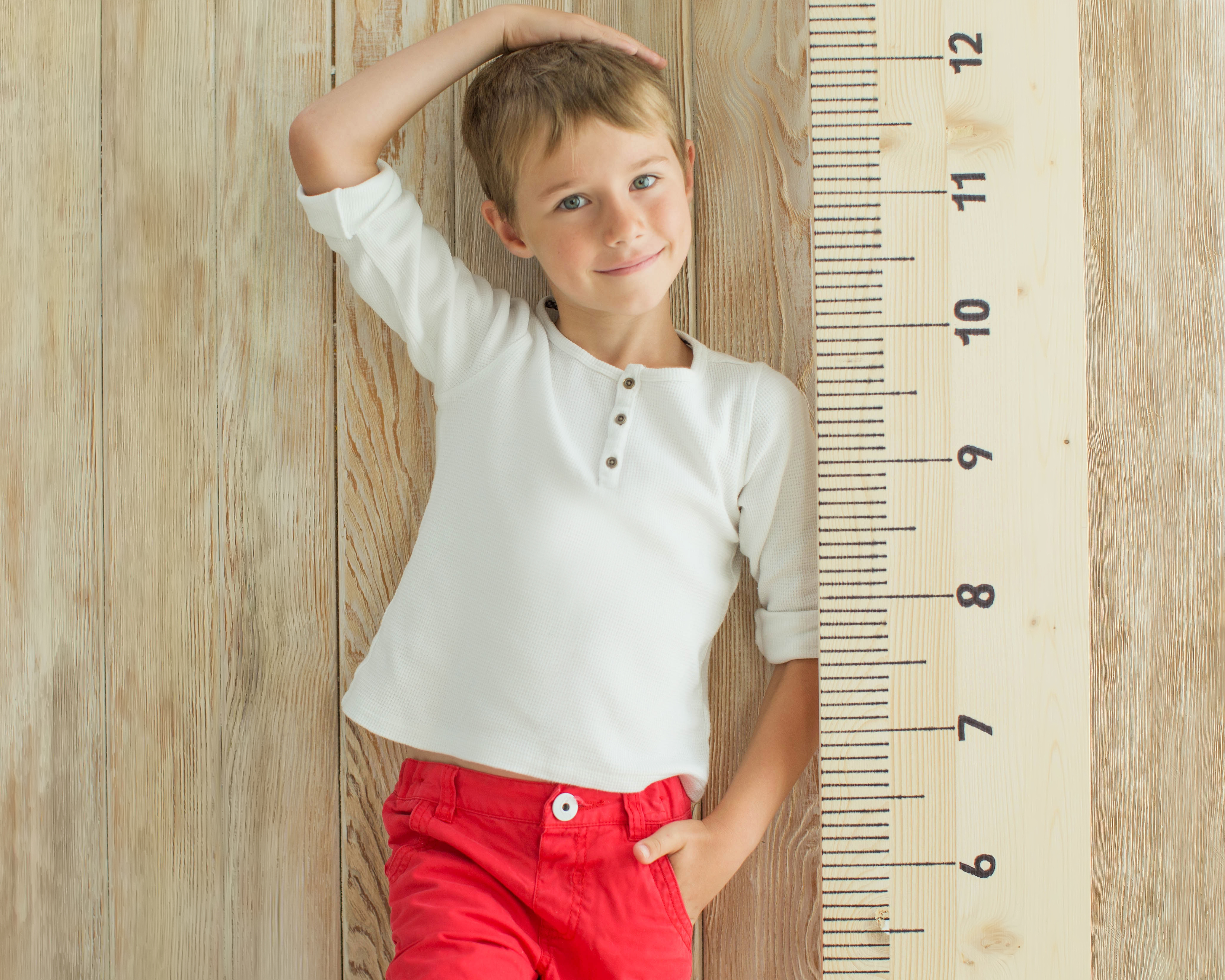 Niño midiendo su crecimiento