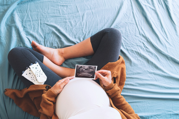 Mujer embarazada mirando una ecografía de su bebé