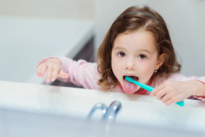 Niña cepillándose la lengua