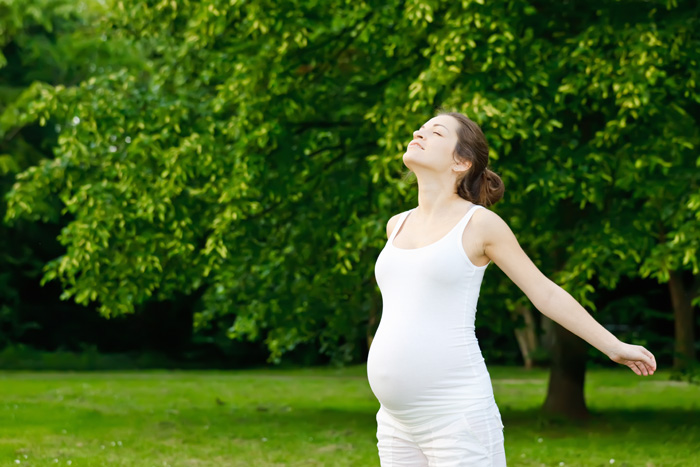 Mujer embarazada respirando al aire libre