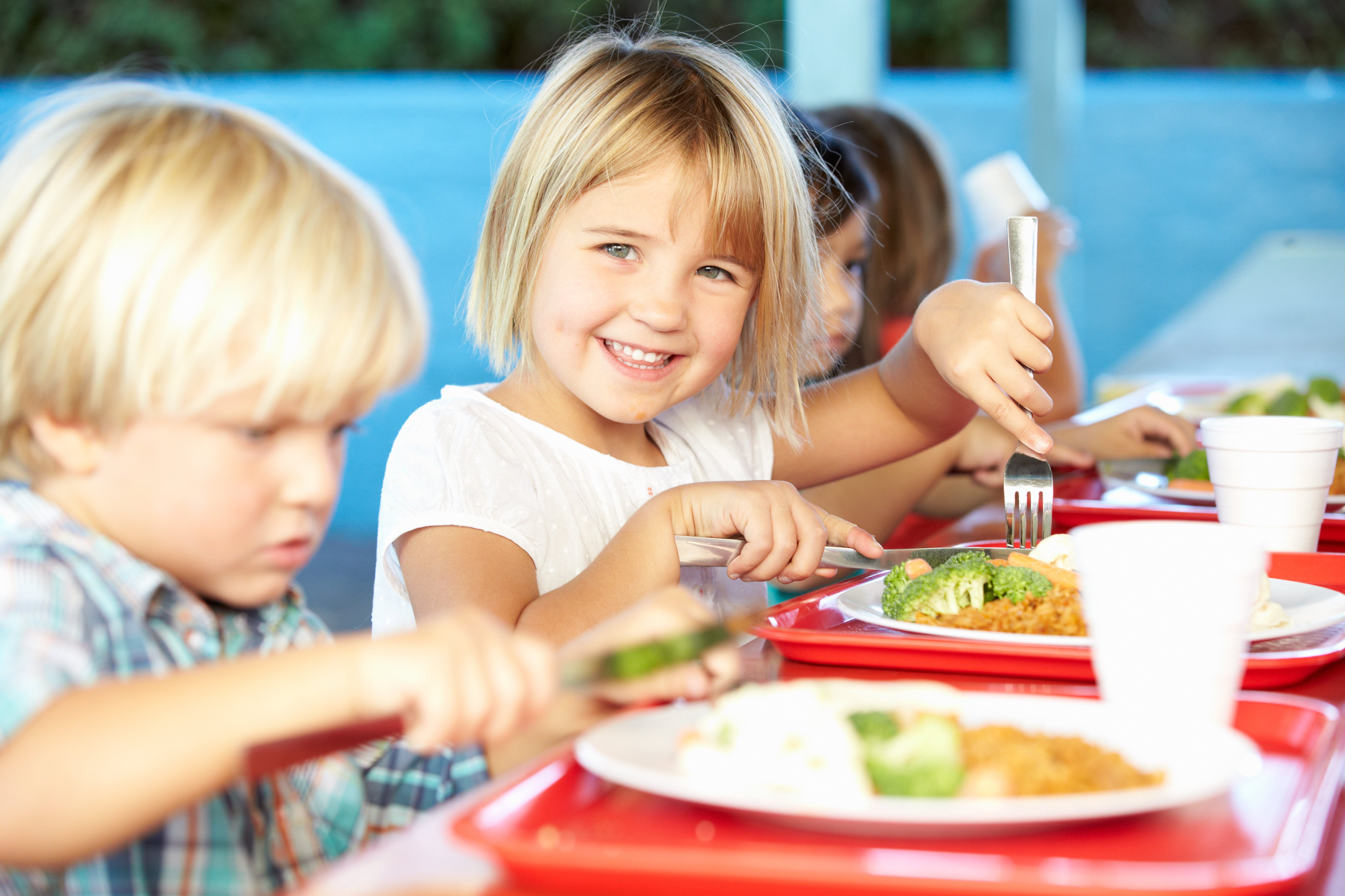 Grupo de niños comiendo en el comedor del colegio