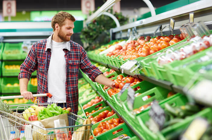 Hombre comprando fruta y verdura para combatir el estreñimiento